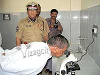 Home Minister peeping into a microscope